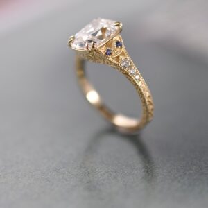 Side profile of a gold-toned ring with an openwork setting and small accent stones.